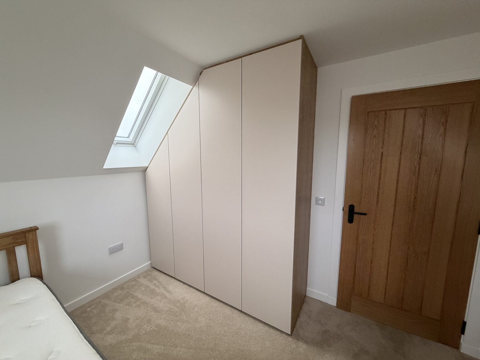 Sloped Ceiling Wardrobes: Make Every Inch Count 2 Sloped ceiling bedroom with a fitted wardrobe by Komandor Scotland.